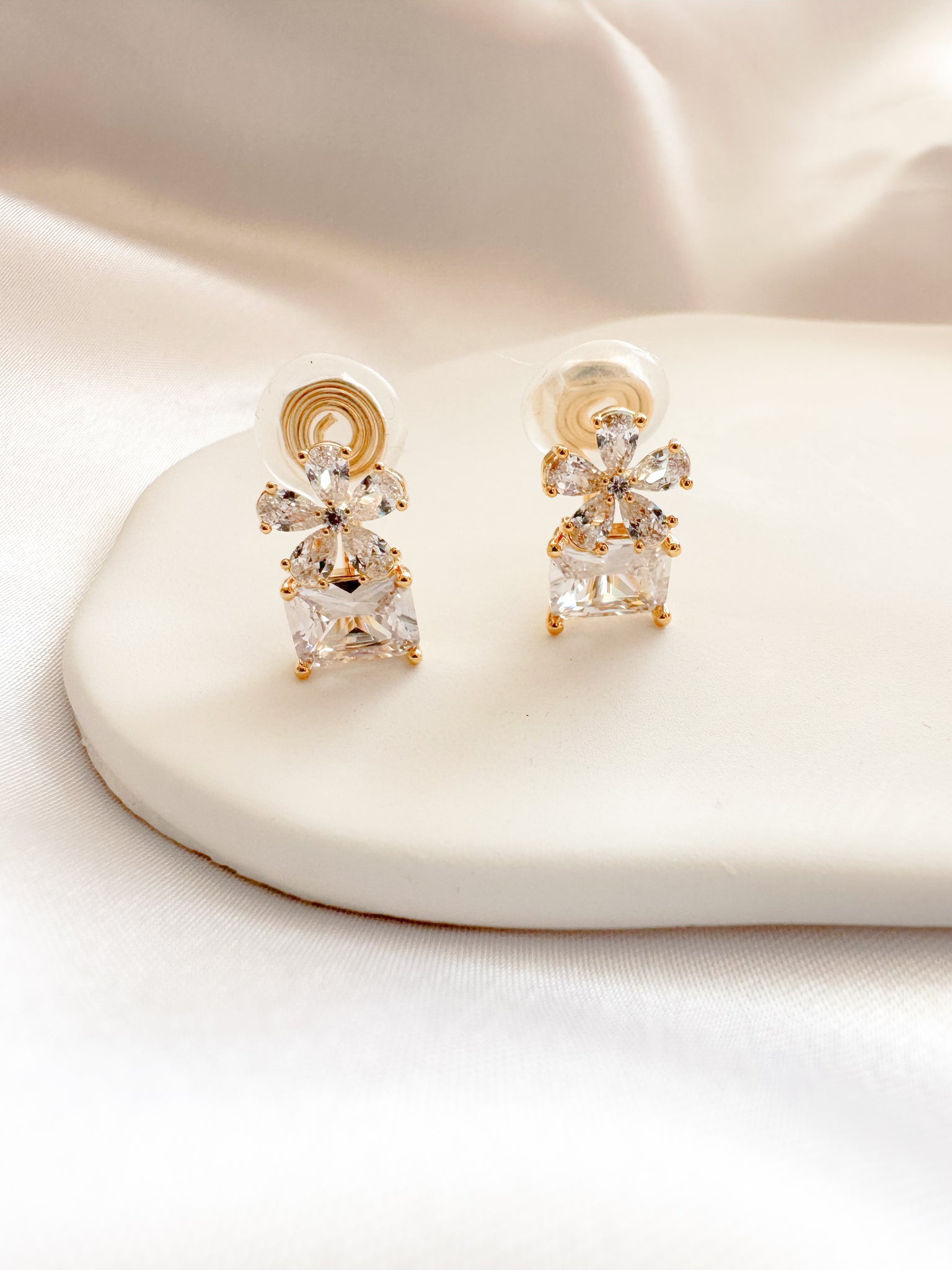 gold & white cubic zirconia shaped into a flower atop a square gem clipon earrings
