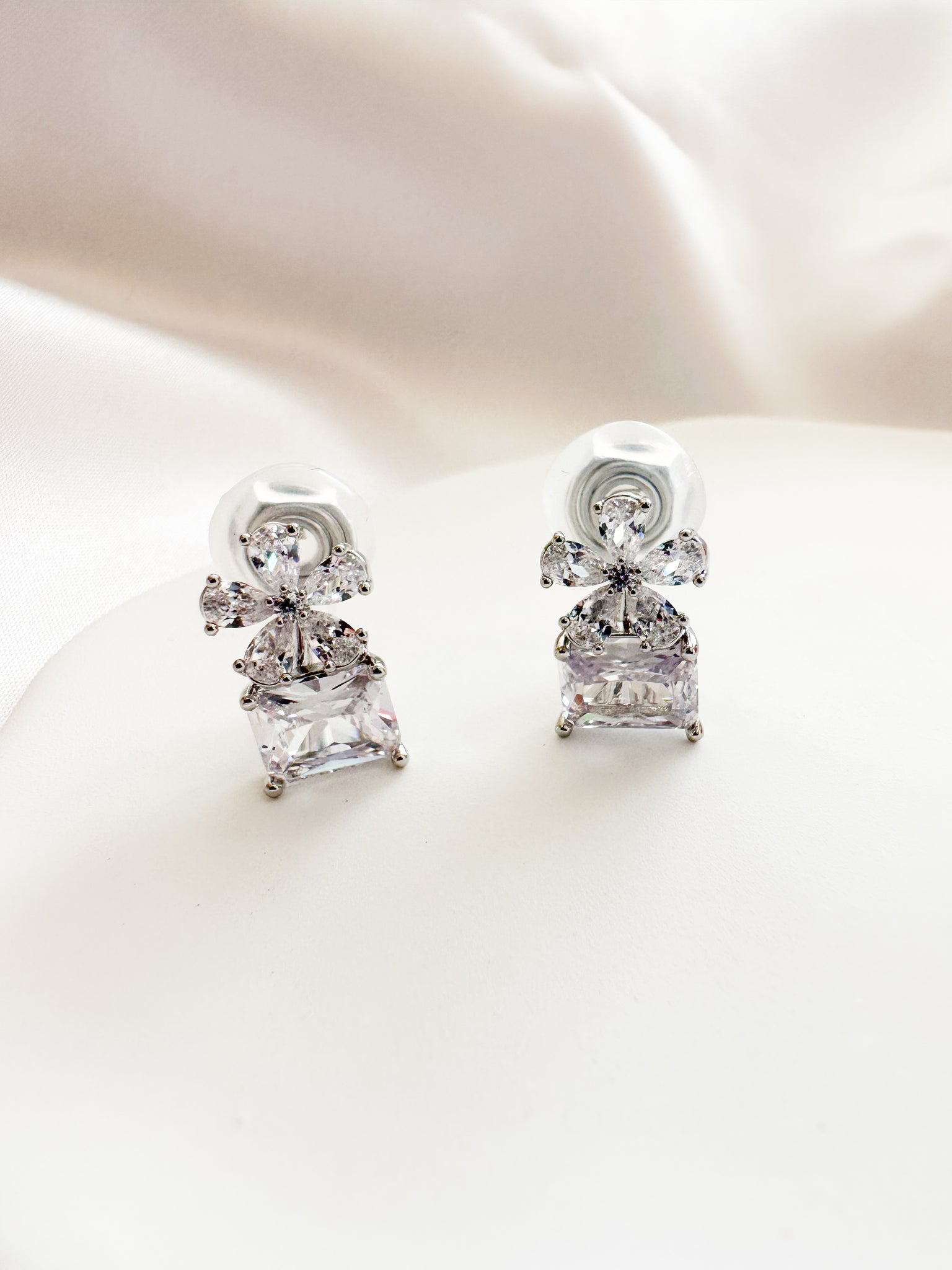 silver & white cubic zirconia shaped into a flower atop a square gem clipon earrings