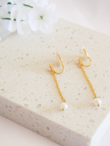 Long dangle clip-on earrings with a pearl charm, designed for comfortable wearing throughout the day.