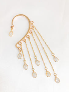 gold ear wrap with white teardrop charm dangling with chains