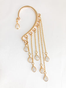 gold ear wrap with white teardrop charm dangling with chains