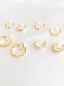 Add some glam to your wardrobe with our bundle of different gold clip-on hoop earrings. This set features four pairs of earrings, each with a unique design. Amy Clip-on Hoops, Twisted Clip-on Hoops, Ella Clip-on Hoops, and Jessika Clip-on Hoops